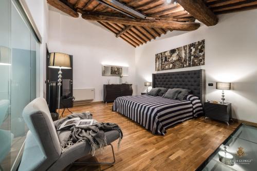 a bedroom with a bed and a couch in a room at Villa Guinigi Dimora di Epoca Exclusive Residence & Pool in Lucca