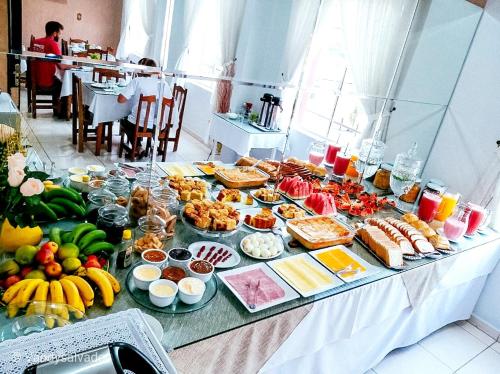 una mesa con muchos tipos diferentes de comida en ella en Hotel Riosulense en Rio do Sul