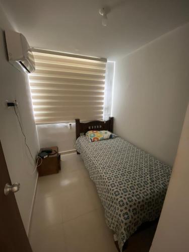 a small room with a bed and a window at Torino Barranquilla- Miramar in Barranquilla
