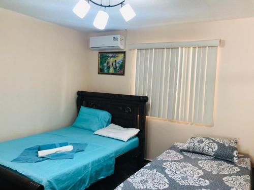 1 dormitorio con 2 camas individuales y sábanas azules en Apartamento Turistico Eisamar en San Andrés