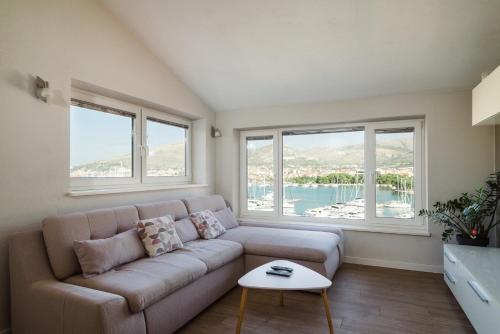 ein Wohnzimmer mit einem Sofa und 2 Fenstern in der Unterkunft Kamerlengo in Trogir