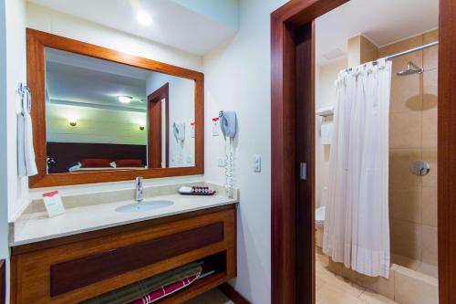 a bathroom with a sink and a mirror and a shower at Hotel Rincon de Puembo; BW Signature Collection in Puembo