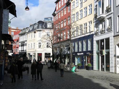 Un groupe de personnes marchant dans une rue avec des bâtiments dans l'établissement ApartmentInCopenhagen Apartment 358, à Copenhague