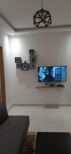a living room with a tv on a white wall at Zayatine RDC in Tunis