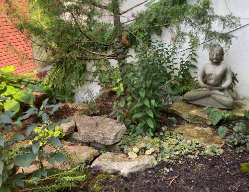 a statue of a buddha sitting in a garden at Cascades Inn in Bloomington