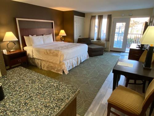 a hotel room with a bed and a desk at Cascades Inn in Bloomington