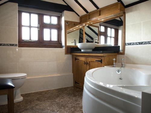 a bathroom with a tub and a toilet and a sink at Brambles Cottage in Great Malvern