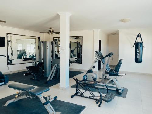 a gym with several exercise equipment in a room at Tranquil Eagle Beach Condo, sleeps 4 to 6 in Palm-Eagle Beach