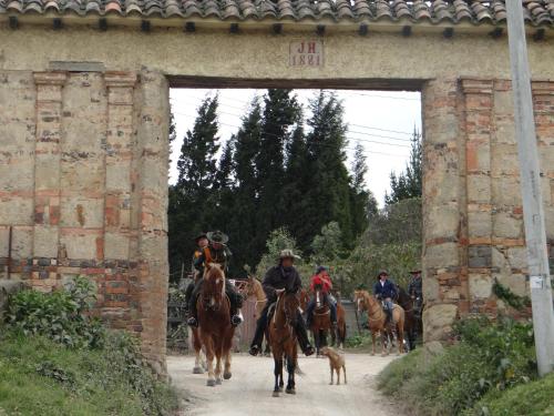 a group of people riding horses under a bridge at La Isabela Estancia Ecuestre in Tabio