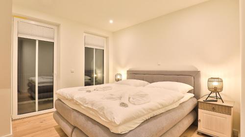 a bedroom with a large bed and a window at Strandhaus Zingst Apartment 15 in Zingst