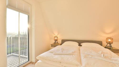 ein Schlafzimmer mit einem Bett und einem großen Fenster in der Unterkunft Strandhaus Zingst Penthouse Seeblick in Zingst