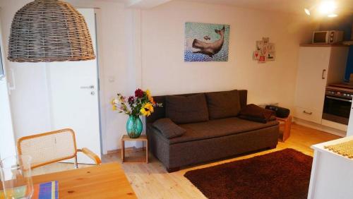 - un salon avec un canapé et un vase de fleurs dans l'établissement Haus "Zur Seebrücke" Strandkorb, à Zingst