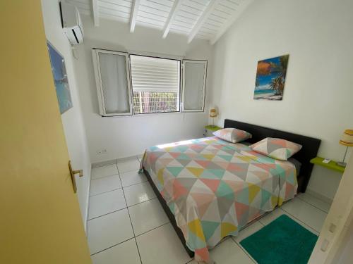 a small bedroom with a bed and a window at PARADIS DES SABLES in Les Galets