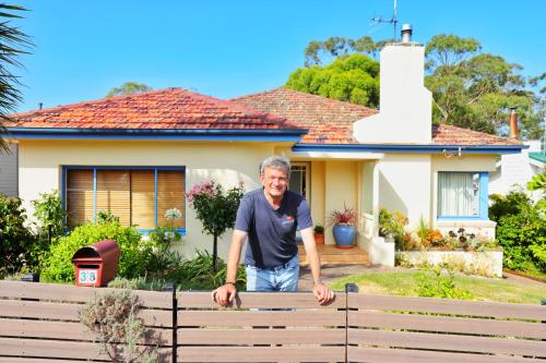 a man standing in front of a house at City Escape Taroona in Taroona