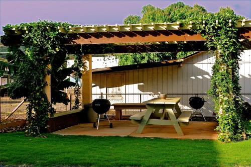 a pergola with a picnic table in a yard at The West Inn Kauai in Waimea