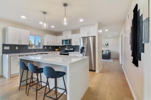 a kitchen with white cabinets and blue bar stools at The Estate at Gold Dust in Scottsdale