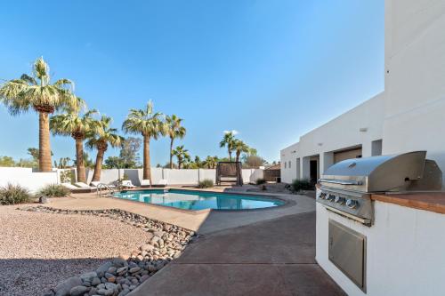 a backyard with a swimming pool and a grill and a house at The Estate at Gold Dust in Scottsdale