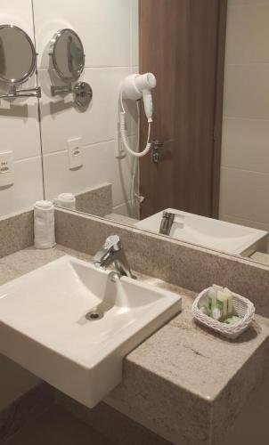 a bathroom with a white sink and a mirror at Cond VISTA AZUL in Pedra Azul