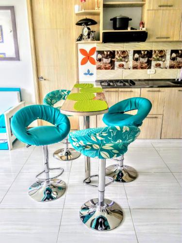 a kitchen with four blue chairs and a table at PeñalisaKapoSalSar in Girardot