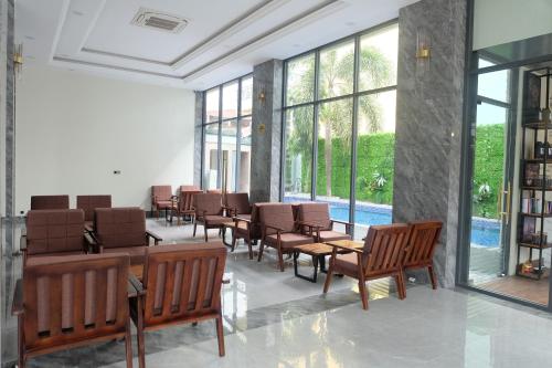 a waiting room with chairs and tables and windows at Twin Hotel Kampot in Kampot