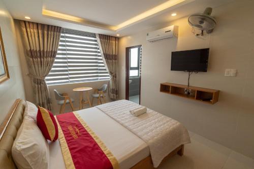 1 dormitorio con 1 cama y TV en la pared en Lam Kiều Hotel en Vung Tau