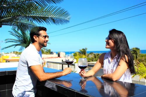 a man and woman sitting at a table with glasses of wine at Casa Wandy in Isla Mujeres