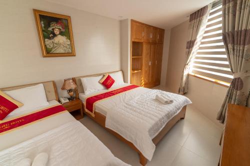 a bedroom with two beds and a window at Lam Kiều Hotel in Vung Tau