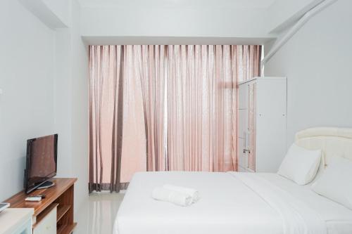 Katil atau katil-katil dalam bilik di Fully Furnished Studio with Comfort Design Majestic Point Serpong Apartment By Travelio