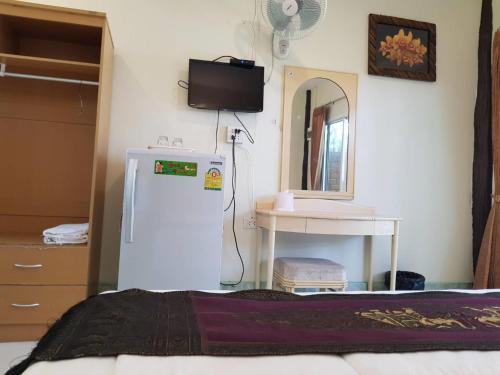 Zimmer mit einem kleinen Kühlschrank und einem Spiegel in der Unterkunft Discovery House Hotel SHA Plus in Nai Yang Beach