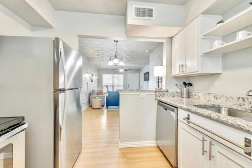 a kitchen with white cabinets and a stainless steel refrigerator at Global Cup Urban Relaxation 2 BR Apartment in Dallas
