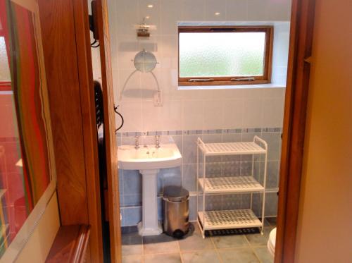 a small bathroom with a sink and a window at Whitley Coach House in Whitley