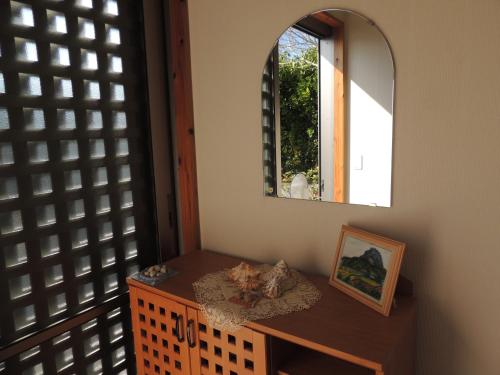 びせ崎の宿　海潮音 في موتوبو: غرفة مع طاولة ومرآة عليها