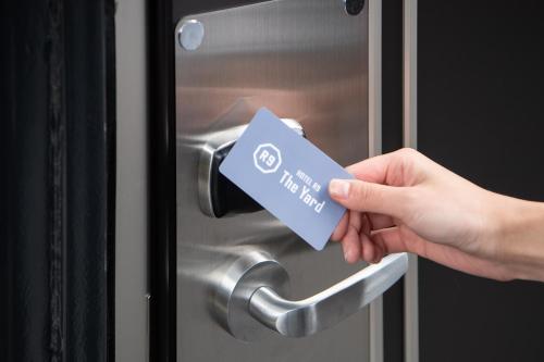 a person holding a credit card in a door at HOTEL R9 The Yard Tokoname in Tokoname