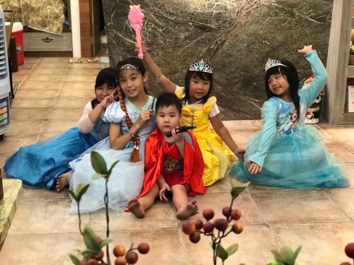 four children dressed in princess costumes sitting on the floor at 花蓮 達芙妮花園民宿 in Jian