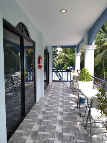 um pátio com cadeiras e mesas num edifício em Azulea Lodging House Oslob em Oslob