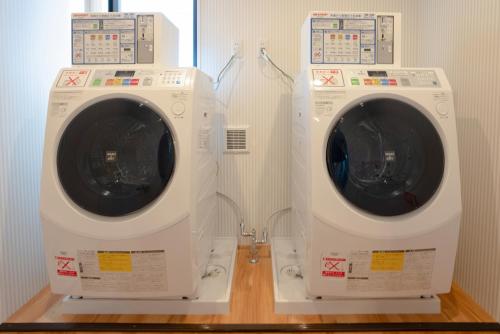 two washing machines sitting next to each other in a room at HOTEL R9 The Yard Tokoname in Tokoname