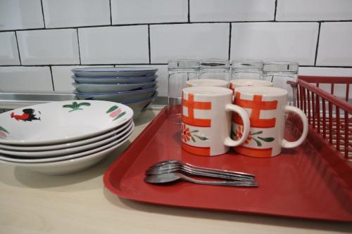 a red tray with cups and plates and utensils at Zen66 @ Roxy Serviced Apartment in Kuching
