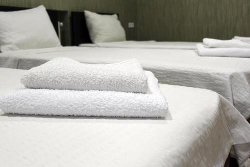 2 camas blancas con toallas encima en Chveni sakhli, en Tiflis
