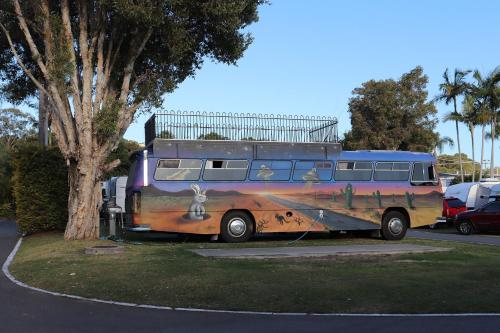 a bus with a painting on it parked next to a tree at Nobby Beach Holiday Village in Gold Coast