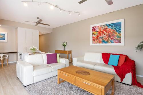 a living room with two white couches and a table at Darwin Waterfront Luxury Suites in Darwin