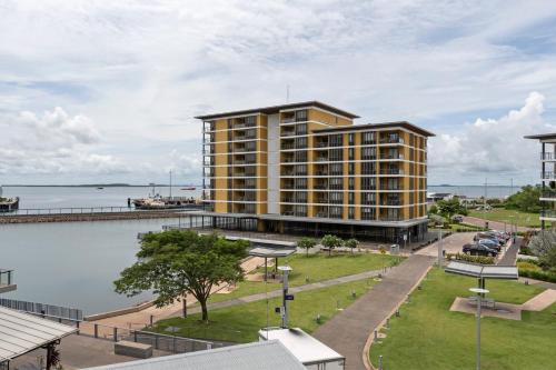 a large yellow building next to a body of water at Darwin Waterfront Luxury Suites in Darwin