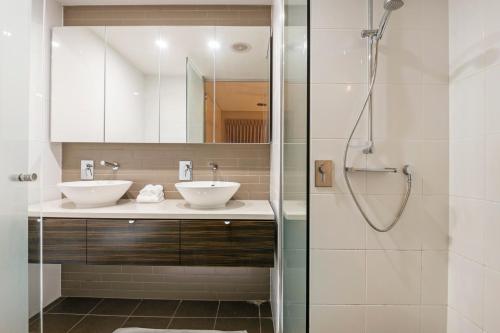 a bathroom with two sinks and a shower at Darwin Waterfront Luxury Suites in Darwin