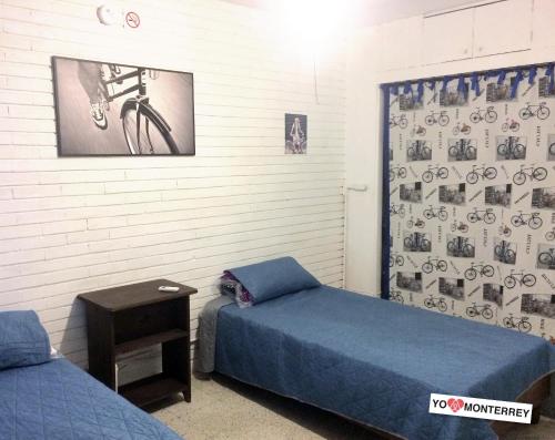 una habitación con 2 camas y una foto de una bicicleta en la pared en Departamento completo a pasos de Santa Lucia mty, en Monterrey