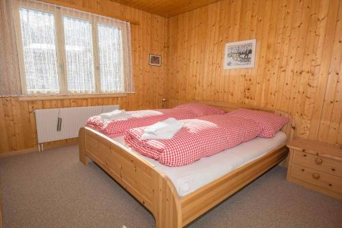 een slaapkamer met een bed in een houten kamer bij Chalet Apollo in Adelboden