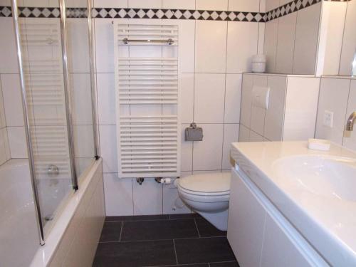 a bathroom with a toilet and a shower and a sink at Ferienwohnung Silberdistel in Adelboden