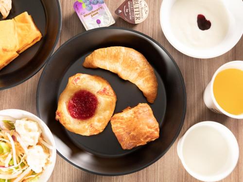a black plate with croissants and jam on a table at Super Hotel Ishikawa Nomineagari Smart Inter in Nomi