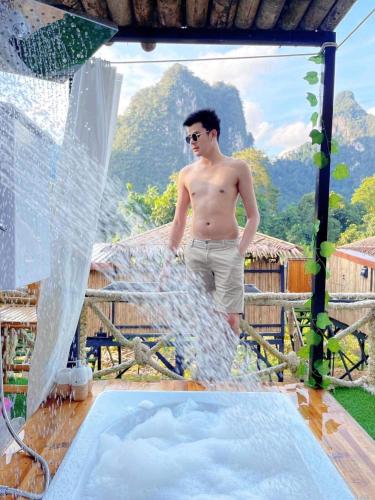 a man is standing next to a water fountain at Bridge Hill Cafe Glamping in Khao Sok