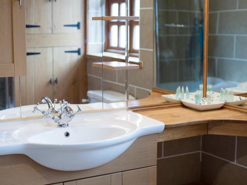 a bathroom with a white sink and a shower at Yew Tree Cottage in Great Malvern