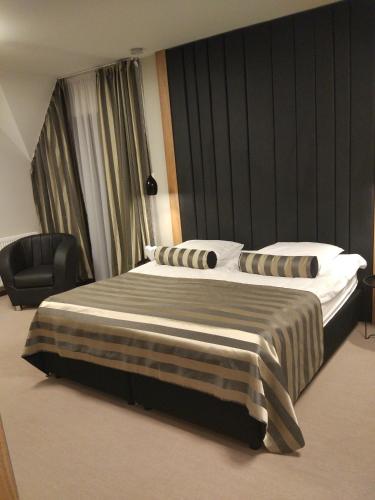 a hotel room with a bed and a chair at Bulwary Biznes in Mielec