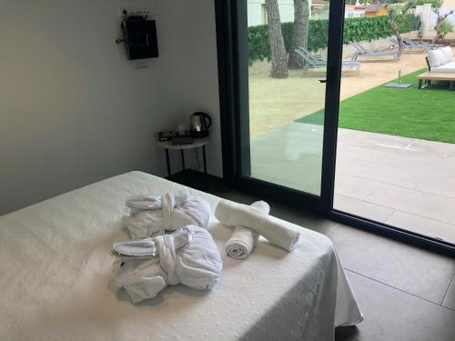 Les tres CalesにあるLA CASA DE LA OLIVERA Luxurious houseの大きな窓のあるベッドにタオルが置かれた部屋